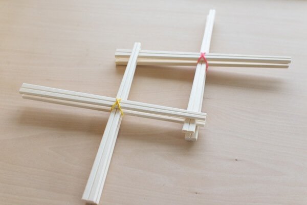 割りばしでできた２つの「×」を交互に重ねます
